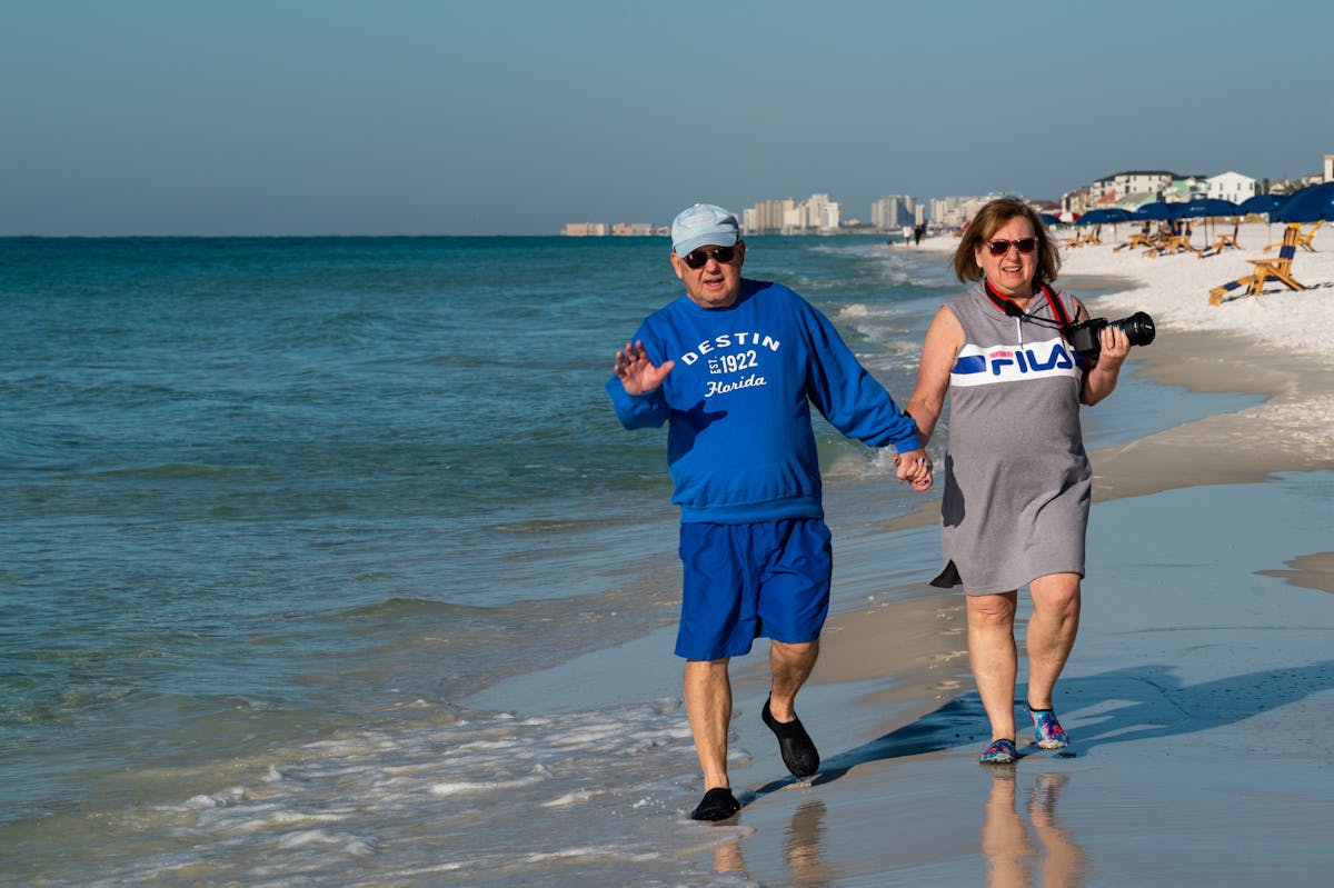 Happy retired couple walking on the beach